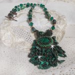 Pendentif Emerald avec un cabochon ovale en Malachite orné de chips avec cristaux : perles rondes et toupies Emerald. S’ajoute des perles en forme d’olives. Brodés sur fermoir en T. Un style Ethnique